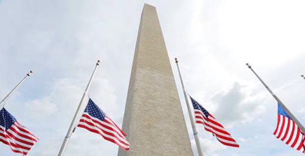 The Washington Monument surrounded by half mast flags