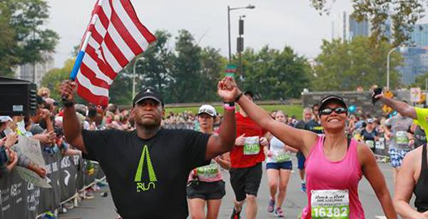Two runners, one carrying the American Flag