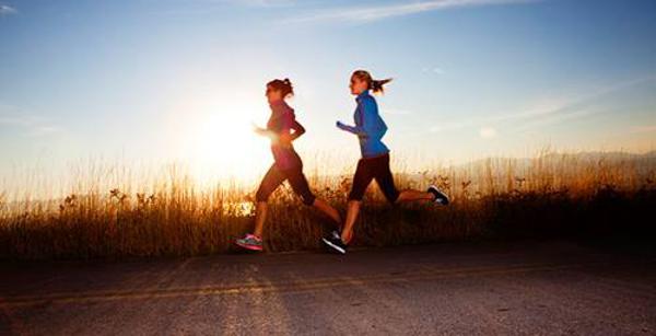 two girls running against the sunset