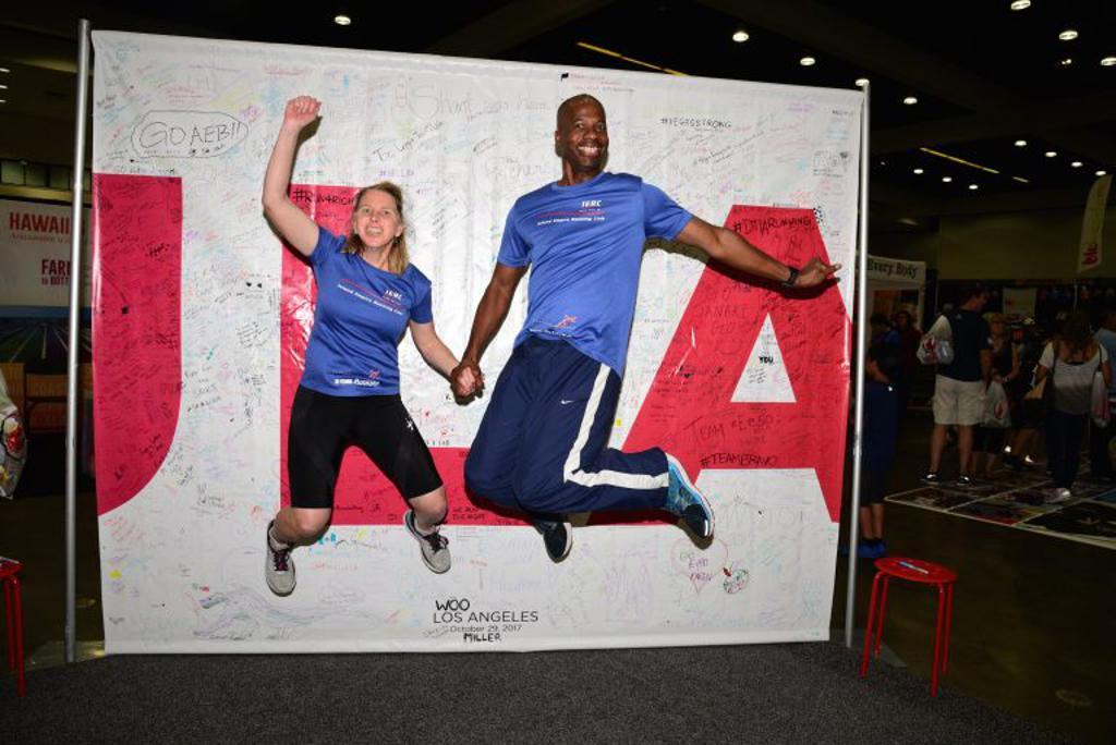 Two jumping in front of the rock n roll marathon shop