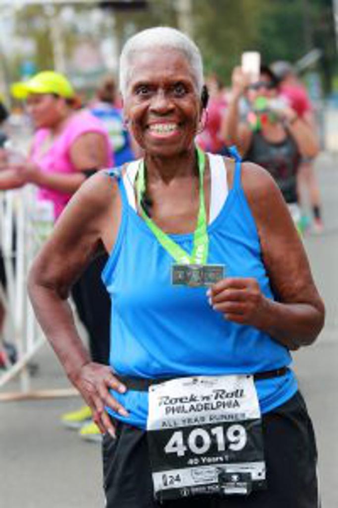 Lorraine Cephus proudly holding her new half marathon medal.